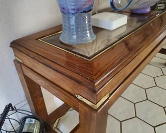 Sofa table beveled glass top. Wood base/trim with brass accents
