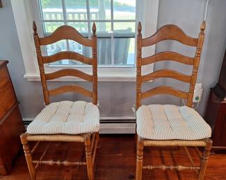 There are four matching ladder-back chairs