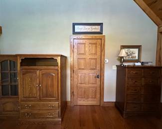 Tall chest of drawers along with an entertainment center.