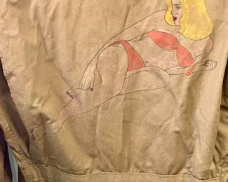  original, authentic World War II U.S. Army M1941 field jacket with custom "nose art" style trench art, featuring a hand-painted pin-up girl titled "Slave Girl"