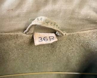  original, authentic World War II U.S. Army M1941 field jacket with custom "nose art" style trench art, featuring a hand-painted pin-up girl titled "Slave Girl"