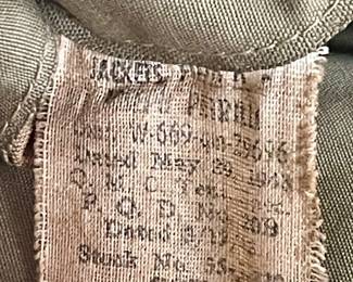 original, authentic World War II U.S. Army M1941 field jacket with custom "nose art" style trench art, featuring a hand-painted pin-up girl titled "Slave Girl"