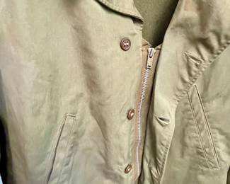  original, authentic World War II U.S. Army M1941 field jacket with custom "nose art" style trench art, featuring a hand-painted pin-up girl titled "Slave Girl"