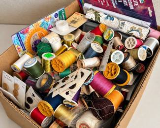 b Assorted Sewing Supplies Collection with Threads, Patterns, and Accessories
