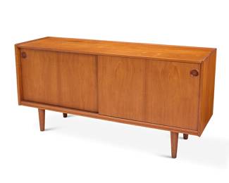 2055 A Danish Modern teak credenza Mid-20th century With shallow upper gallery above sliding cabinet doors opening to reveal a single shelf to the right and two sliding felt-lined drawers and a small glass shelf to the left, raised on attenuated legs Metal Danish Furniture Makers Control tag applied to underside Height 29 1/2 in, width 59 in., depth 17 3/4 in. Estimate: $500 - $700