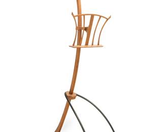 2213 Bud Tullis (1938-2017) A sculpted walnut and metal music stand, circa 1990 The sheet music rest with adjustable height and vertically swiveling angle With burn marked signature: Bud Tullis; impressed: 0205 Height 81 1/4 in., width 26 in., depth 39 1/2 in., dimensions variable Estimate: $2,000 - $3,000