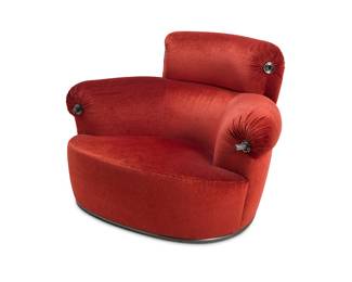 2083 Luigi Caccia Dominioni (1913-2016) A 'Toro' armchair for Azucena, 1980s Designed 1973 for Monticello Country Club near Milan Red velvet upholstery and metal "handles," raised on two front casters With applied metal tag: Azucena Height 33 in., width 48 in., depth 41 1/2 in. Estimate: $800 - $1,200