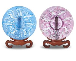 2070 A pair of Phoenix Consolidated Glass 'Dancing Nymphs' chargers from the Martelé line Late 20th/early 21st century Each depicting dancing classical figures, raised on an Asian-style wood display stand Unmarked 2 pieces Height of each 2 3/8 in., diameter 17 3/4 in.; height of stands 15 in., width 13 3/4 in., depth 6 3/4 in. Estimate: $800 - $1,200