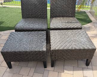 Two wicker patio chairs with foot stools