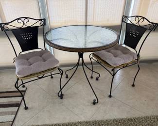 Small glass top and iron scroll patio set 