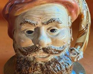 Ceramic character jug by Beswick, England, model 2095 depicting Falstaff. Features hand-painted details, feathered handle, and embossed marks on the base. Classic collectible from Beswick pottery.