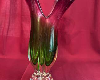 Murano-style art glass vase with vibrant green and cranberry coloring, featuring a freeform flared rim and four clear glass feet. Crafted in hand-blown glass with a smooth, polished base.