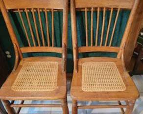 Wooden dining chairs including two cane seat chairs and one chair with a blue vinyl upholstered seat. Each chair features a slatted backrest design and wood frame construction.