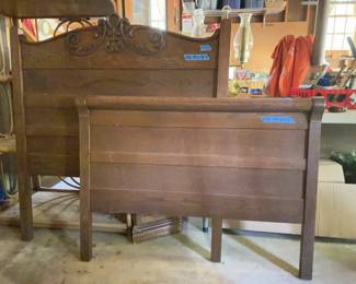Carved wood headboard and footboard featuring scroll motif detail on the headboard. The dimensions are marked as headboard 44 x 46 inches tall and footboard 44 x 42 inches tall. Both pieces show wear, scratches, and a split at a leg joint.