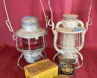 Metal railroad lanterns marked 'RF&P RR' and 'ACL RR', one with a clear globe and one with a red globe. Includes a Yarborough & Sons 'Golden Rain' tobacco tin, Requaâ€™s Charcoal Tablets tin, and Sydnor & Hundley brass advertising piece. 