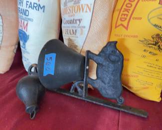 Cloth ham bags: Gwaltney Williamsburg, Virginia Country Farm, Jamestown, and FFA Virginia Ham. Also features a cast iron farm bell with pig figure and turning wheel.