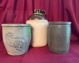Three stoneware pieces including a brown top handled jug (13 inches tall), a crock with cobalt blue decoration (8 inches tall), and a gray crock marked 'J.M. Hokeson Strasburg, VA' (8.5 inches tall).