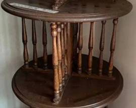 Four-tier round wood revolving bookcase with turned spindle supports. The bookcase measures 46 inches high and 20 inches in diameter. Suitable for organizing books or displaying items.
