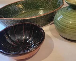 Pottery pieces including a green glazed ribbed vase, a brown glazed bowl from The Old Salem Collection by Dave Fernald, and a green and brown speckled oval tray.