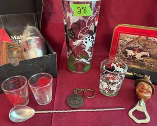 Maker's Mark cocktail set with branded shaker and napkins, glass tumblers with horse and fox hunting designs, a Jim Beam keychain, a metal bottle opener with a character handle, a long bar spoon, and coasters featuring equestrian hunt scenes (base is labeled Johnny Walker Red).