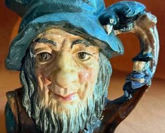 This Royal Doulton character jug features Rip Van Winkle with a detailed handle depicting a raven and a small figure. Marked on the base: Rip Van Winkle D6438, copyright 1954, Doulton & Co Limited.
