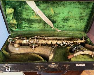 C.G. Conn alto saxophone in brass with engraved floral pattern, includes original hard case, mouthpiece, neck, and ligature. The saxophone shows signs of age-related wear and oxidation. Serial number and keywork visible on body.