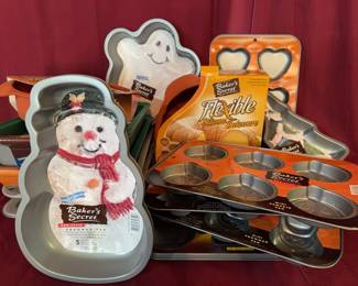 Baker's Secret bakeware including themed metal baking pans and flexible silicone bakeware. Features snowman, ghost, Christmas tree, heart, pumpkin, and Easter egg shapes.