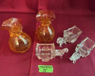 amber crackle glass pitchers with flared rims and attached decorative rings, with three clear glass horse-drawn cart figurines. The tallest piece measures 5 inches.