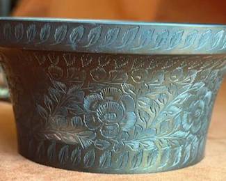1959 India-marked etched brass bowl, decorative brass harness ornaments with horse, hand, and barrel motifs, a commemorative belt buckle, brass bells, and a metal key chain with a tree motif.