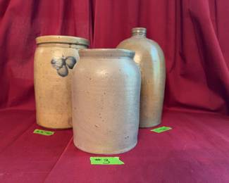 Three stoneware pieces: a 9.5-inch tall crock with blue decoration, an 11-inch tall handled jug with a narrow mouth, and a plain stoneware jar.