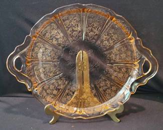 Pink Depression glass tray featuring ornate floral etching, divided into sections and fitted with two handles. This collectible plate is noted for its detailed pressed glass pattern and classic pink hue.