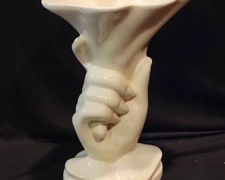 Hull Pottery white porcelain vase shaped as a hand holding a flared vessel. Stands approximately 8 inches in height. Marked "Hull Art" on base.