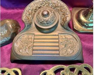 Pair of brass candlesticks, a detailed floral brass inkwell with hinged lid, a commemorative brass paperweight marked '1620' and 'WM. HIGHTON & SONS CO. PIITSBURG', a leaf-shaped brass tray marked 'COPYRIGHT 1950 SUGAR MAPLE', and two ornate brass letter 'R' monograms.