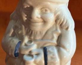Royal Doulton ceramic pitcher, model 410, in the form of a Toby Jug. It features hand-painted blue accents, a tricorn hat rim, and embossed details. The base is marked with 'Royal Doulton' and '410'.
