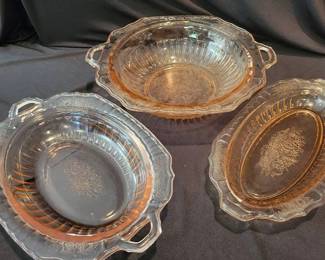 Pink Depression glass serving dishes with floral etched design. Handled oval vegetable bowls and serving platter. Glass showcases ribbed and scalloped detailing.