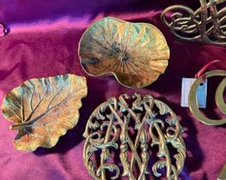 Thomas Jefferson letter bookends, leaf-shaped dishes, decorative letter "W" trivet by Ash Tower, and additional brass trivets marked Cozzani 1984. 