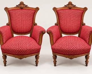 Elegant matching pair of Victorian-style accent chairs featuring richly carved wooden frames, ornate crest detailing, rolled arms, turned front legs, and vibrant red patterned upholstery. These statement chairs would add classic character to a living room, study, entryway, or formal sitting area. Sold as a pair.