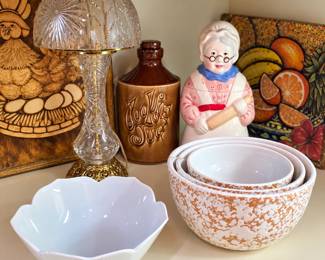 Wonderful collection of vintage kitchen and home décor! Featured items include a cut-glass table lamp, brown ceramic “Cookie Jug,” charming grandmother baker cookie jar, nested speckled mixing bowls, white scalloped serving bowl, and colorful decorative fruit and kitchen artwork. Perfect for vintage kitchen collectors and farmhouse décor lovers!