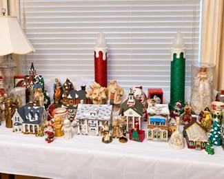 A festive wonderland of Christmas collectibles! This assortment includes lighted village houses and churches, Santa and snowman figures, angels, bells, nativity and religious pieces, ceramic trees, holiday mugs, an angel doll, and oversized red-and-green glitter candle decorations. Plenty of charming pieces for building a holiday village or adding seasonal cheer throughout your home!