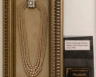 Beautifully framed multi-strand pearl necklace featuring an ornate jeweled clasp. According to the included provenance card, the pearls were owned and worn by Minnie Olivia Hines Amox circa 1940. A lovely vintage display piece with history, elegance, and timeless charm!