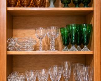 Beautiful collection of vintage and contemporary glassware in rich amber, emerald green, frosted gray, and clear crystal. The assortment includes patterned tumblers, goblets, wine glasses, champagne flutes, cordial glasses, and elegant serving pieces—perfect for entertaining, holiday gatherings, or completing a glassware collection!