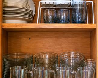 Lovely assortment of kitchen and dining pieces, including classic blue-and-white floral cups and bowls, neutral dinner plates, smoky drinking glasses, clear glass mugs, and stacks of glass plates and bowls. Perfect for everyday dining, entertaining, or adding to an existing collection!