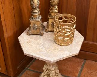 Elegant octagonal accent table featuring a light stone-look top and an ornate carved pedestal base. Displayed with a coordinating pair of tall gold candlesticks and a Z Gallery decorative openwork gold candle holder. Beautiful statement pieces for a traditional or vintage-inspired home!