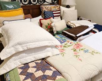 Beautiful assortment of bedding and home linens, including handmade patchwork quilts, floral and embroidered comforters, quilted pillow shams, decorative throw pillows, blankets, sheets, and coordinating fabric pieces. A wonderful selection of traditional, patriotic, and neutral styles for refreshing any bedroom!