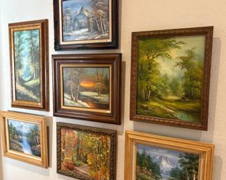 Collection of framed landscape paintings featuring mountain, woodland, river and seasonal scenes in traditional decorative frames.