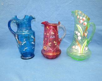 Lot 52. Three pitchers with hand-painted decorations. Blue one has a tight hairline crack.