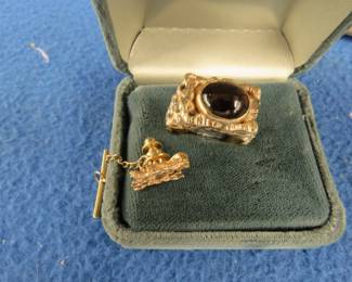 Lot 57. Marked by seller as his personal gold ring with a garnet from Idaho and a tie tac.