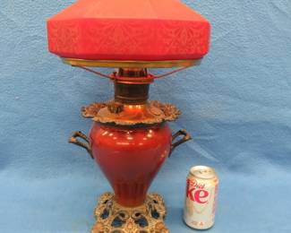 Lot 27. Electrified oil lamp with a cranberry shade. Shade has been repaired.