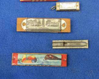 Lot 160. Three novelty harmonicas, one whistle, and a fake wooden harmonica