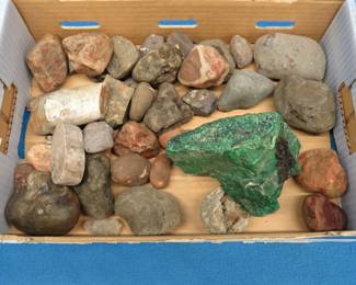 Lot 230. Flat of interesting rocks. The large green item is likely malachite or a copper carbonate. The round specimen that looks like a shell on a rock is a straight-shelled cephalopod. Please see Auctioneer's Notes at the start of this auction.
